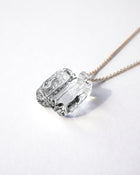 “Clear, glacier‑like glass pieces that catch the light, suspended from an adjustable gold‑plated chain.