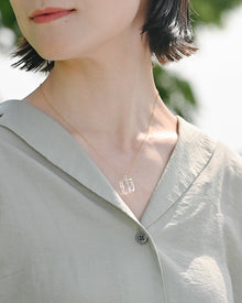 Clear glacier‑like glass fragments that catch the light, suspended from an adjustable gold‑plated chain.