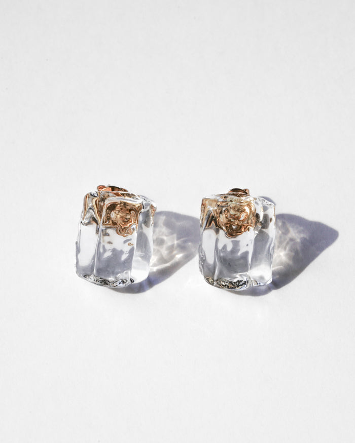 Clear glass fragments reminiscent of melting ice, catching the light on gold‑plated stud posts.