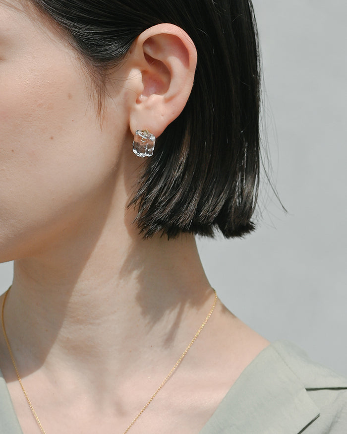 Delicate stud earrings made of transparent, ice‑like glass pieces that glimmer softly, set on gold‑plated posts