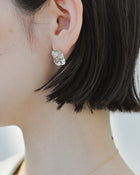 Gold‑plated stud earrings featuring clear glass fragments inspired by melting glaciers.