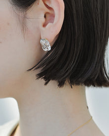 Gold‑plated stud earrings featuring clear glass fragments inspired by melting glaciers.