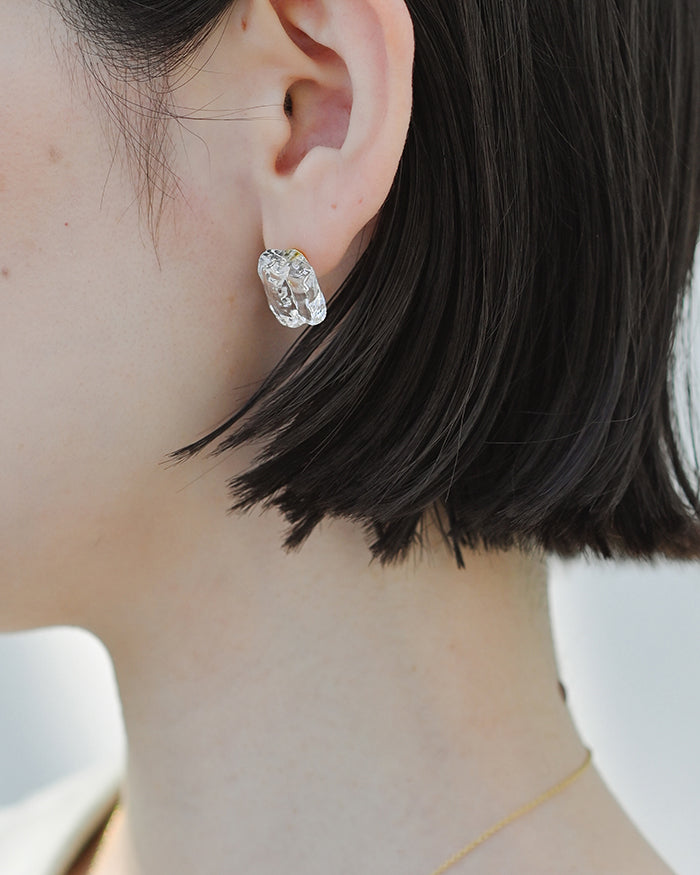 Gold‑plated stud earrings featuring clear glass fragments inspired by melting glaciers.