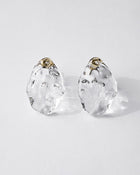 Gold‑plated stud earrings with clear glass shaped like gentle waves of light, shimmering softly like reflections on a lake.