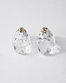 Gold‑plated stud earrings with clear glass shaped like gentle waves of light, shimmering softly like reflections on a lake.