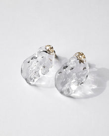Gold‑plated stud earrings with clear glass shaped like gentle waves of light, shimmering softly like reflections on a lake.
