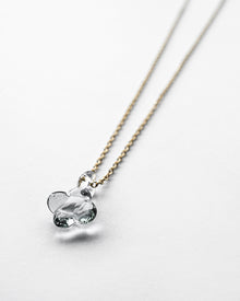 A small hydrangea-shaped glass pendant in soft gray, attached to a brass chain with nickel-free gold plating and an adjustable slide ball.