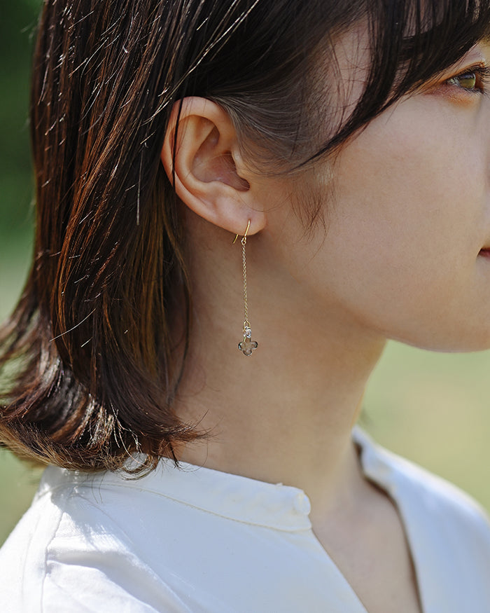 Delicate hydrangea blossoms crafted in soft gray glass hang from fine chains attached to gold‑plated hooks. The earrings offer a subtle, refined shimmer with an elegant and understated tone.
