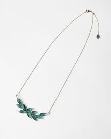 A necklace featuring a gentle arch of fresh green leaves, crafted in glass and suspended from a delicate gold‑plated chain. The design captures the vitality of new spring foliage, as if light has been softly lifted from overlapping leaves and transformed into an accessory.