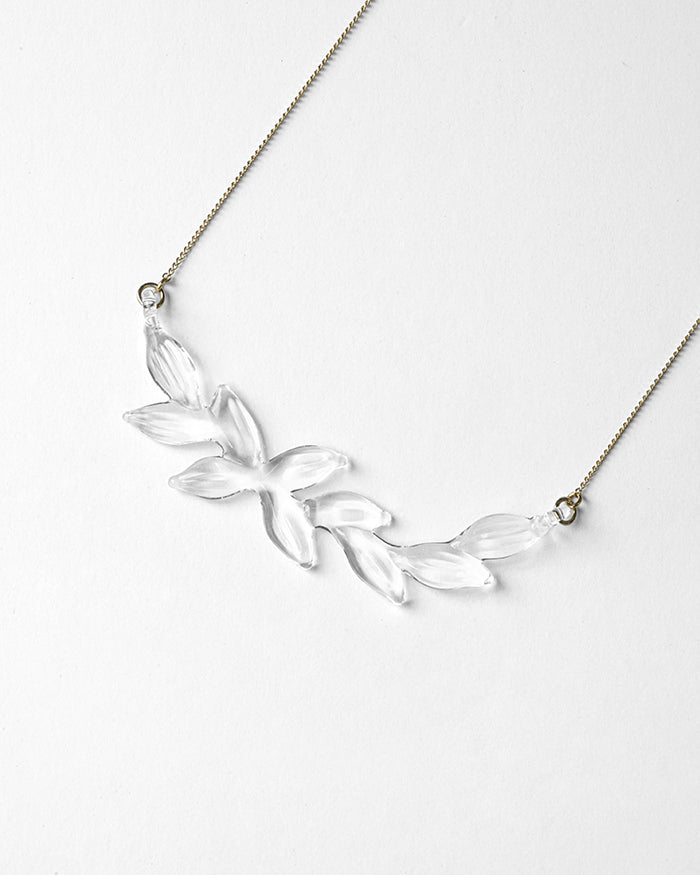 A necklace featuring a gentle arch of fresh green leaves, crafted in glass and suspended from a delicate gold‑plated chain. The design captures the vitality of new spring foliage, as if light has been softly lifted from overlapping leaves and transformed into an accessory.
Clear color.
