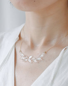 A necklace featuring a gentle arch of fresh green leaves, crafted in glass and suspended from a delicate gold‑plated chain. The design captures the vitality of new spring foliage, as if light has been softly lifted from overlapping leaves and transformed into an accessory.
Clear color.
