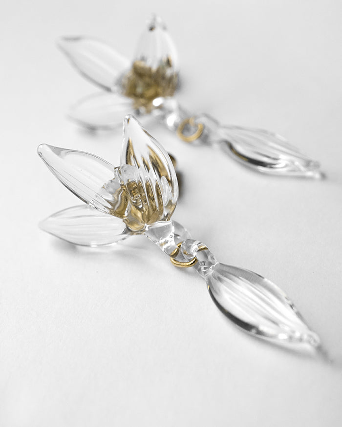 Earrings inspired by the vitality of fresh spring foliage. Delicate leaf‑shaped glass pieces sway gently from stud posts, as if light has been softly lifted from overlapping green leaves and transformed into jewelry.
Clear color