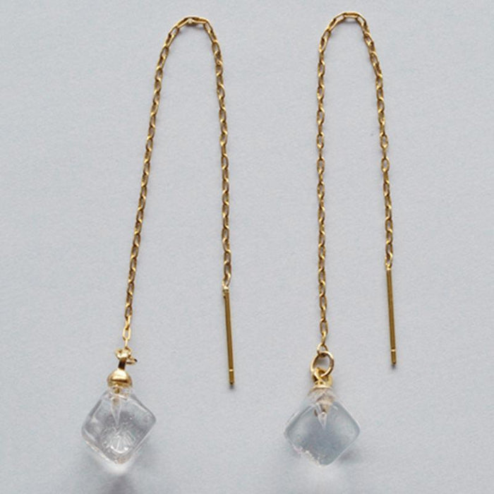 Softly shaped glass cube earrings that feature contrasting frosted and polished surfaces. Handmade melted-look glass cube earrings attached to slender gold-plated chains designed to be threaded through the piercing.