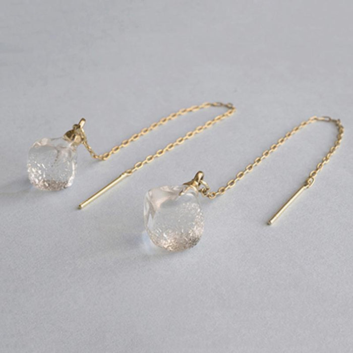 Softly shaped glass cube earrings that feature contrasting frosted and polished surfaces. Handmade melted-look glass cube earrings attached to slender gold-plated chains designed to be threaded through the piercing.