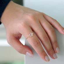 “A gold-plated adjustable ring featuring a soft cube-shaped glass element with contrasting frosted and smooth surfaces that evoke moonlight.