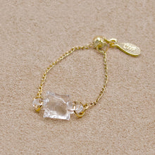 “A gold-plated adjustable ring featuring a soft cube-shaped glass element with contrasting frosted and smooth surfaces that evoke moonlight.