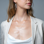 A frosted, sherbet-textured handmade glass pendant hanging from a delicate necklace chain.