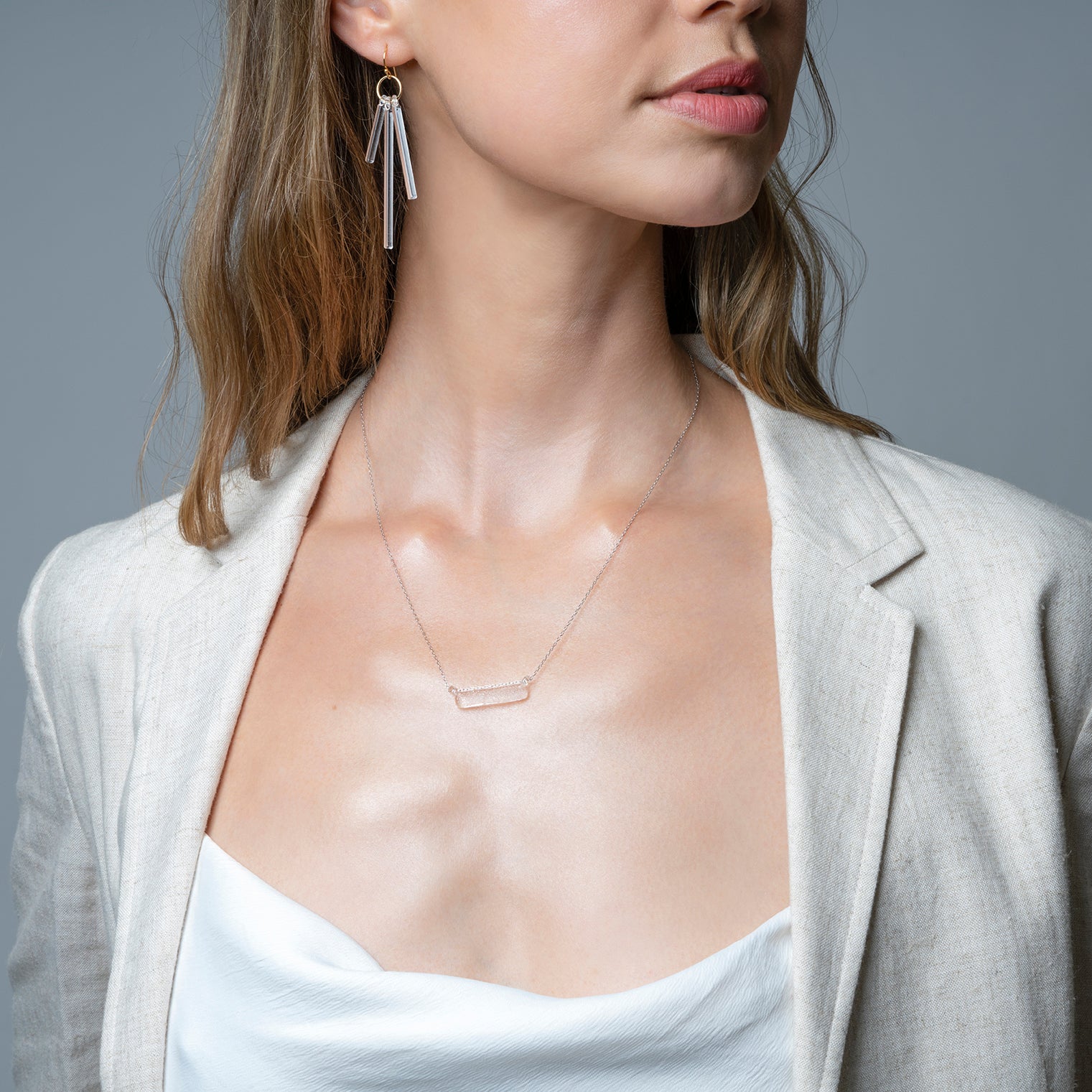 A frosted, sherbet-textured handmade glass pendant hanging from a delicate necklace chain.