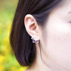 A pair of tiny clear glass flowers attached to gold‑plated earring hooks