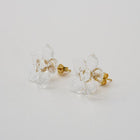A pair of tiny clear glass flowers attached to gold‑plated earring hooks