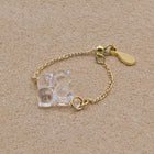 A small four‑petal handmade glass flower set on an adjustable gold‑plated chain ring.