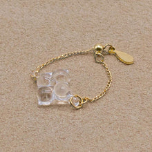 A small four‑petal handmade glass flower set on an adjustable gold‑plated chain ring.