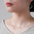 A necklace made of five connected arcs that resemble softly rounded water droplets, attached to a gold‑plated chain with an adjustable sliding ball.