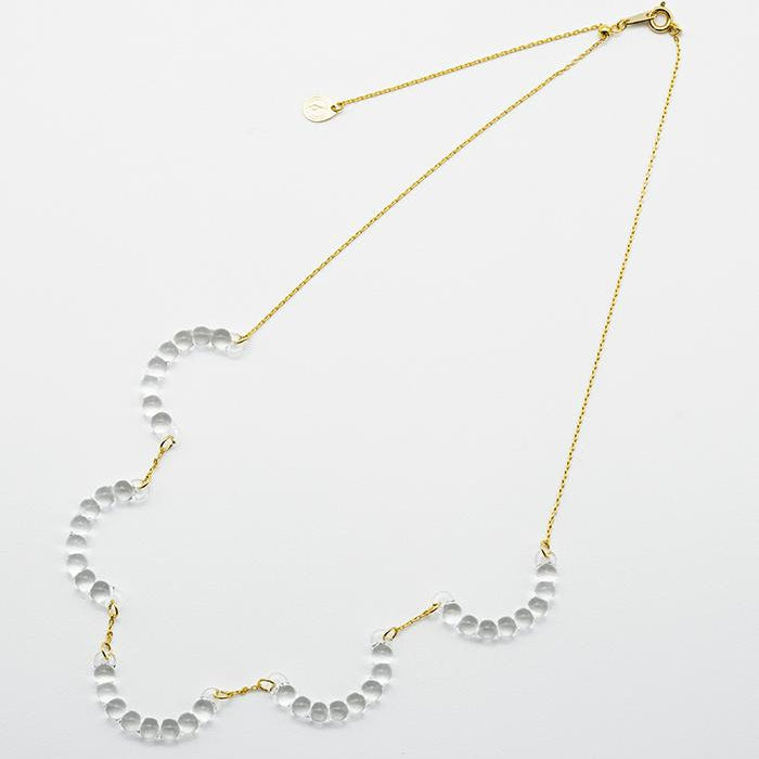 A necklace made of five connected arcs that resemble softly rounded water droplets, attached to a gold‑plated chain with an adjustable sliding ball.