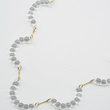 A necklace made of five connected arcs that resemble softly rounded water droplets, attached to a gold‑plated chain with an adjustable sliding ball.